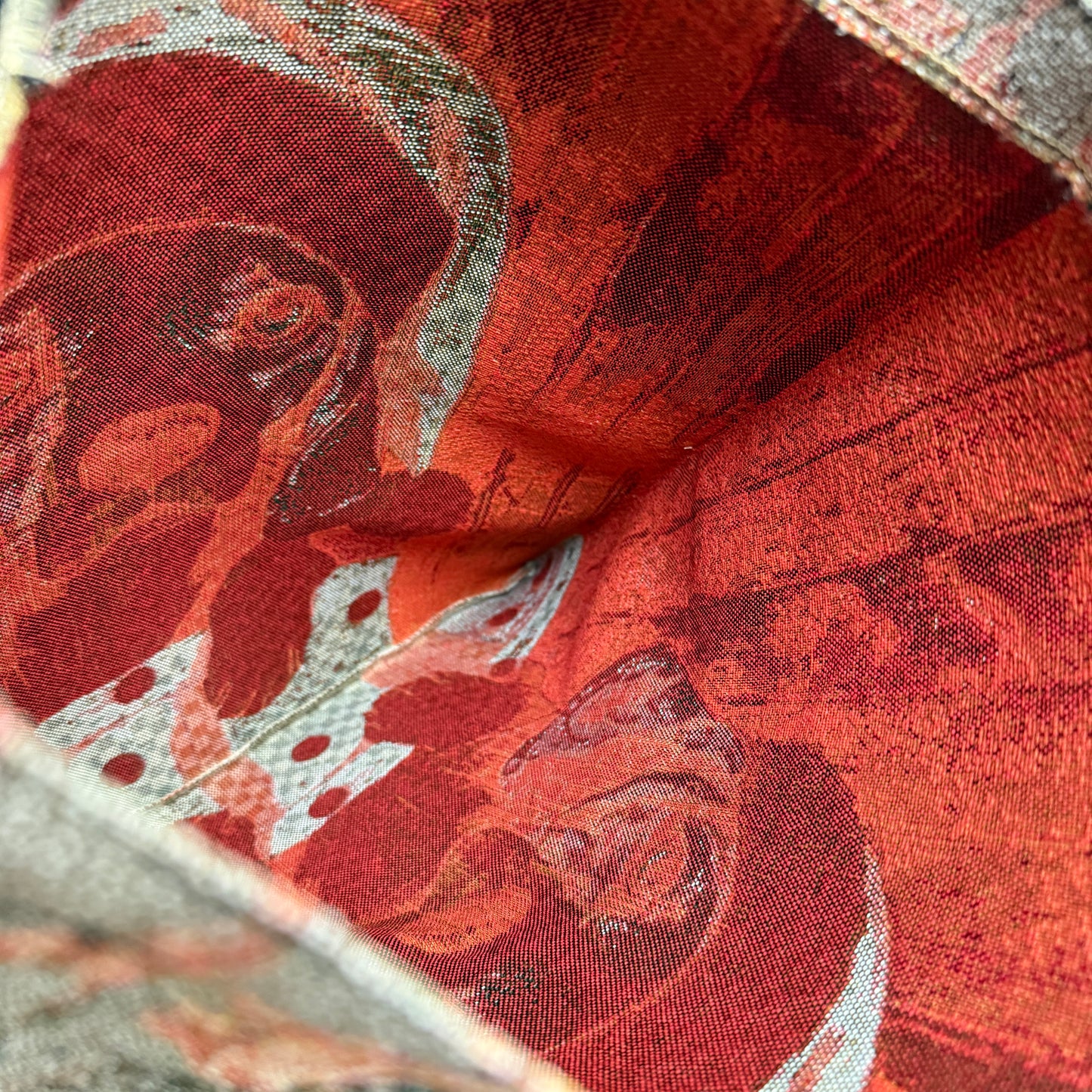 Close-up of a red fabric with intricate patterns and textures.