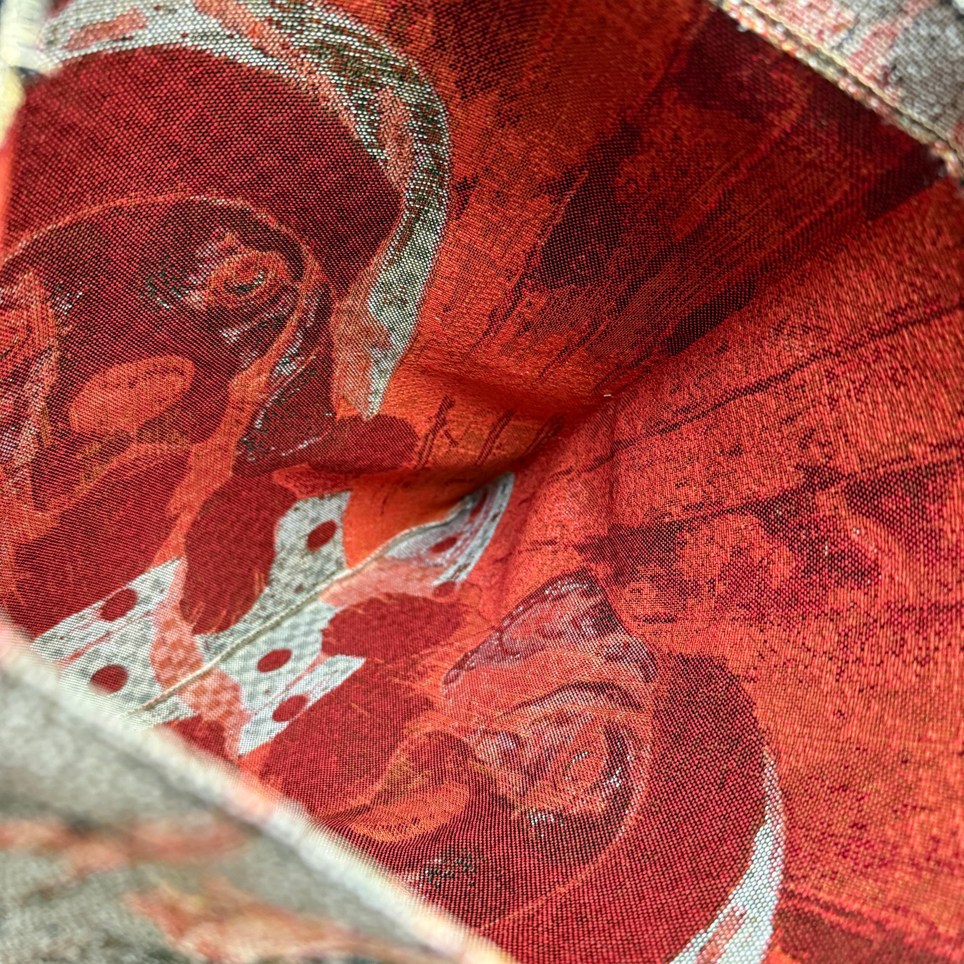 Close-up of a red fabric with intricate patterns and textures.